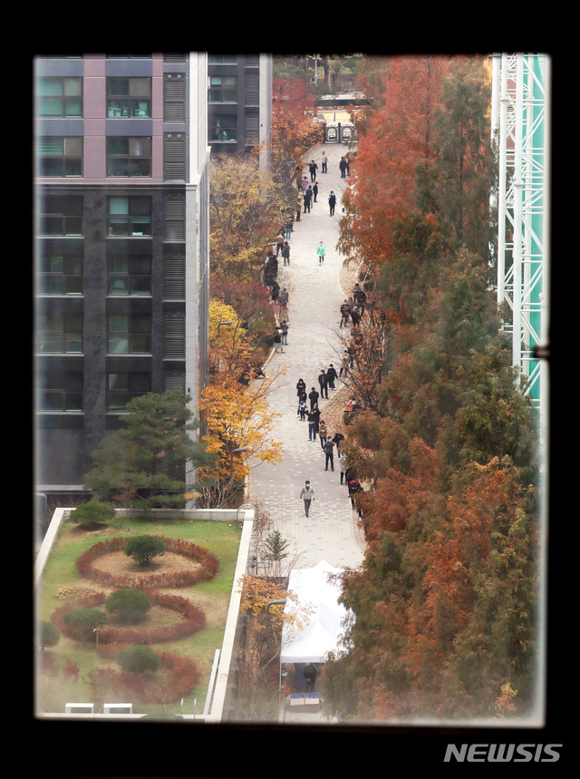 [서울=뉴시스]김병문 기자 = 서울 서초구 아파트 내 입주민만 출입하는 사우나에서 신종 코로나바이러스 감염증(코로나19) 집단감염이 발생한 가운데 17일 오후 아파트 단지 내 선별진료소에서 주민들이 검사를 받기 위한 대기줄이 창틀 사이로 보이고 있다. 2020.11.17. dadazon@newsis.com