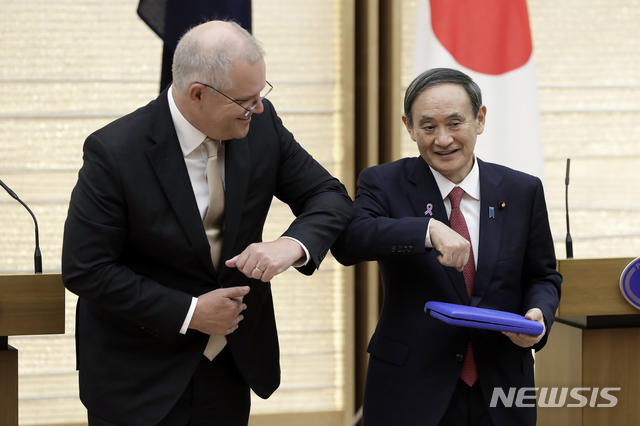 [도쿄=AP/뉴시스] 스가 요시히데(菅義偉) 일본 총리가 17일 도쿄 관저에서 스콧 모리슨 호주 총리와 팔꿈치 인사를 하고 있다. 두 정상은 이날 정상회담을 마친 뒤 공동 기자회견을 열고 안보, 경제 분야에서 많은 합의를 이뤄냈다고 발표했다. 2020.11.17.