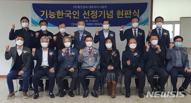 [창원=뉴시스] 홍정명 기자=한국산업인력공단 송달영(앞줄 왼쪽 세 번째부터) 경남지사장이 18일 창원국가산단 내 ㈜동진금속을 방문해 나상조 대표이사에게 '이달의 기능한국인' 메달과 기념패를 전달한 후 기념촬영을 하고 있다.(사진=한국산업인력공단 경남지사 제공) 2020.11.18. photo@newsis.com