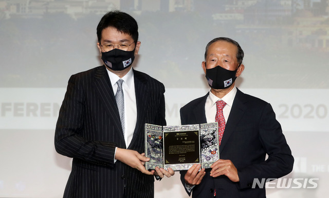 [서울=뉴시스]홍효식 기자 = 조원태 한진그룹 회장이 18일 오전 서울 영등포구 여의도 전국경제인연합회(전경련) 회관에서 열린 '제32차 한미재계회의 총회 2일차'에 참석해 허창수 전경련 회장에게 고 조양호 전 한진그룹 회장에 대한 공로패를 전달받은 뒤 기념촬영을 하고 있다. 2020.11.18.&nbsp; yesphoto@newsis.com