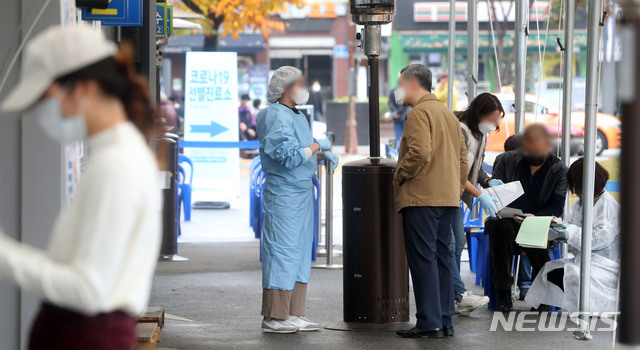 [서울=뉴시스]홍효식 기자 = 신종 코로나바이러스 감염증(코로나19) 신규 확진자가 313명으로 집계된 18일 오후 서울 영등포구 보건소에 마련된 선별진료소를 찾은 시민들이 검사를 위해 접수하고 있다. 2020.11.18.&nbsp; yesphoto@newsis.com