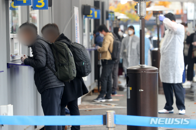 [서울=뉴시스]배훈식 기자 = 서울과 경기, 광주 사회적 거리두기가 1.5단계로 격상된 19일 오후 서울 영등포구 영등포보건소 신종 코로나바이러스 감염증(코로나19) 선별진료소에서 검사를 받으려는 시민들이 문진을 받고 있다. 2020.11.19. dahora83@newsis.com