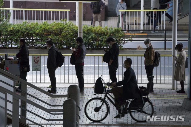 [도쿄=AP/뉴시스] 20일 일본 도쿄에서 시민들이 신종 코로나바이러스 감염증(코로나19) 예방을 위해 마스크를 착용하고 출근하기 위해 버스 줄을 서 있다. 2020.11.20.
