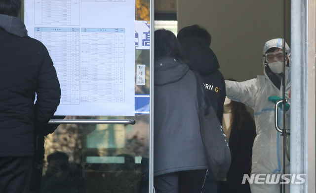 [서울=뉴시스]김명원 기자 = 2021학년도 서울시 공립(국립, 사립) 중등교사, 보건사서영양전문상담특수(중등)교사 임용후보자 선정경쟁 제1차시험이 치러지는 21일 오전 서울 용산구 용산고등학교에서 임용시험 참석 수험생들이 발열체크 및 거리두기 등 방역수칙 을 준수하며 입실하고 있다. 2020.11.21. kmx1105@newsis.com
