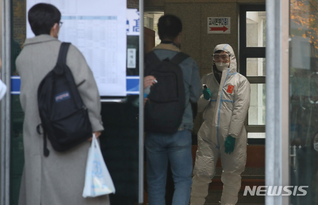 [서울=뉴시스]김명원 기자 = 2021학년도 서울시 공립(국립, 사립) 중등교사, 보건사서영양전문상담특수(중등)교사 임용후보자 선정경쟁 제1차시험이 치러지는 21일 오전 서울 용산구 용산고등학교에서 임용시험 참석 수험생들이 발열체크 및 거리두기 등 방역수칙 을 준수하며 입실하고 있다. 2020.11.21.&nbsp; kmx1105@newsis.com