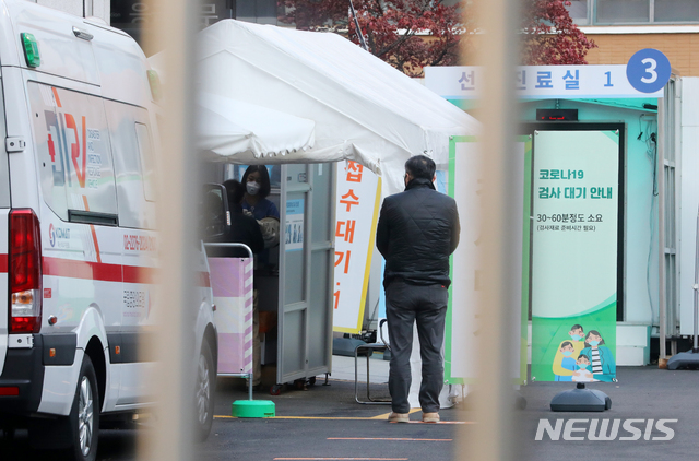 [서울=뉴시스]배훈식 기자 = 신종 코로나바이러스 감염증(코로나19) 대응 수도권 사회적 거리두기 2단계 격상을 하루 앞둔 23일 오전 서울 중구 국립중앙의료원 선별진료소에서 검사를 받으려는 시민들을 순서를 기다리고 있다. 2020.11.23.&nbsp; dahora83@newsis.com