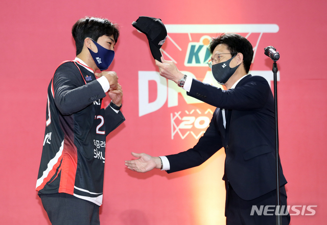 [서울=뉴시스]이윤청 기자 = 서동철 감독이 23일 서울 송파구 잠실학생체육관에서 열린 2020 KBL 국내신인선수 드래프트에서 전체 1라운드 2순위로 부산KT에 지명된 연세대 박지원에게 모자를 씌워주고 있다. 2020.11.23. radiohead@newsis.com