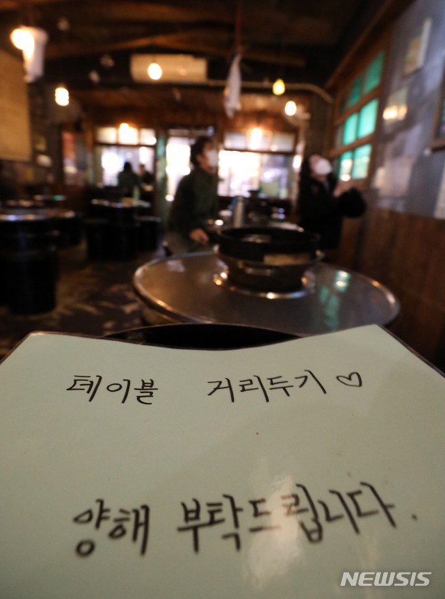 [서울=뉴시스] 고범준 기자 = 신종 코로나바이러스 감염증(코로나19) 확산 여파로 오는 24일 0시부터 사회적 거리 두기 2단계가 격상되는 23일 오후 서울 마포구 홍대거리의 한 음식점 테이블에 거리두기 안내문이 놓여 있다. 음식점은 저녁 9시까지는 영업이 가능하지만 그 이후부터는 포장과 배달만 허용된다. 2020.11.23.  bjko@newsis.com