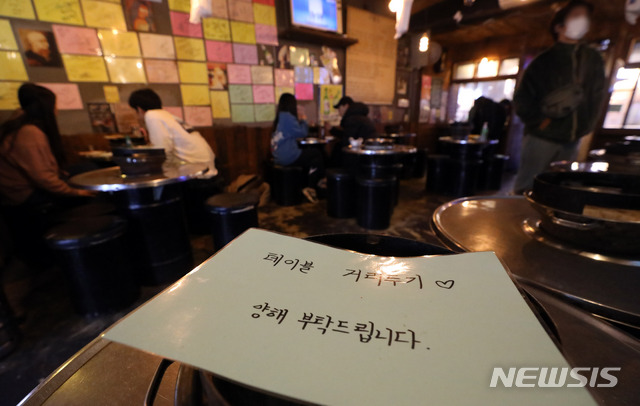 [서울=뉴시스] 고범준 기자 = 신종 코로나바이러스 감염증(코로나19) 확산 여파로 오는 24일 0시부터 사회적 거리 두기 2단계가 격상되는 23일 오후 서울 마포구 홍대거리의 한 음식점 테이블에 거리두기 안내문이 놓여 있다. 음식점은 저녁 9시까지는 영업이 가능하지만 그 이후부터는 포장과 배달만 허용된다. 2020.11.23.&nbsp; bjko@newsis.com