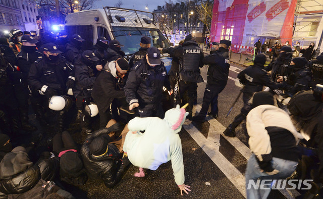 [바르샤바=AP/뉴시스]23일(현지시간) 폴란드 바르샤바에 있는 교육부 청사 앞에서 폴란드 경찰이 낙태 권리 지지 시위대와 대치하고 있다. 폴란드 바르샤바 등지에서 낙태권을 둘러싼 여성 주도의 시위가 격화하면서 경찰이 시위 관계자 여러 명을 구금했다. 2020.11.24.