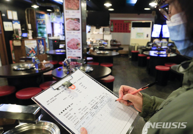 [서울=뉴시스] 박민석 기자 = 수도권 사회적 거리두기가 2단계로 격상된 24일 오후 서울 마포구 홍대 거리의 한 음식점에서 서울시 식품정책과 직원이 방역 지침 준수 사항을 점검하고 있다. 2020.11.24.&nbsp; mspark@newsis.com