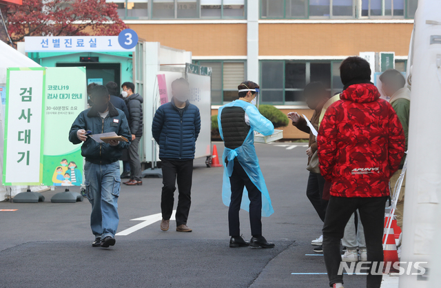 [서울=뉴시스]배훈식 기자 = 수도권 사회적 거리두기 2단계 시행에도 신종 코로나바이러스 감염증(코로나19) 확진자 수가 300명대를 기록한 25일 오전 서울 중구 국립중앙의료원 선별진료소에서 코로나19 검사를 받은 시민들이 영수증을 받고 있다. 2020.11.25. dahora83@newsis.com