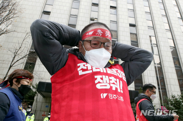 [서울=뉴시스]김병문 기자 = 민주노총 조합원이 25일 오후 서울 여의도 더불어민주당 서울시당 앞에서 '노동개악 저지! 전태일3법 쟁취! 민주노총 총파업 총력투쟁 전국동시다발대회'에 참석해 머리띠를 두르고 있다. 2020.11.25.&nbsp; dadazon@newsis.com