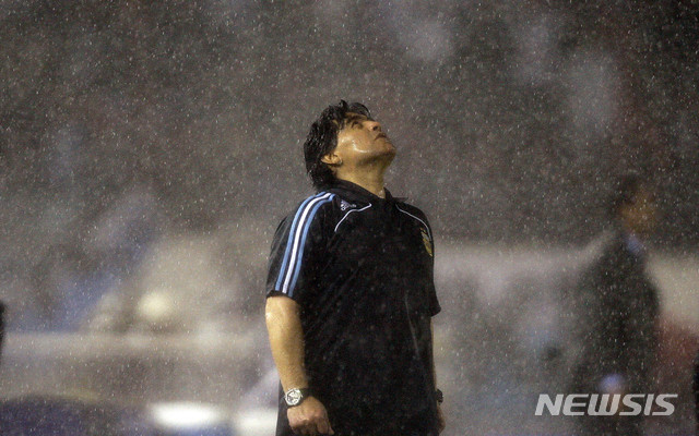 [부에노스아이레스=AP/뉴시스]아르헨티나 축구 영웅 디에고 마라도나가 25일(현지시간) 부에노스아이레스 자택에서 심장마비로 타계했다. 향년 60세. 마라도나는 이달 초 만성 경막하혈종 진단을 받아 뇌수술을 받고 퇴원한 지 2주 만에 숨졌다. 사진은 2009년 10월 10일 부에노스아이레스에서 열린 2010 월드컵 예선 축구 페루 vs 아르헨티나의 경기 중 쏟아지는 빗속에서 아르헨티나의 디에고 마라도나 감독이 고개를 들고 있는 모습. 2020.11.26. 