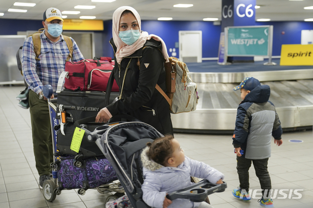 [뉴욕=AP/뉴시스]신종 코로나바이러스 감염증(코로나19)을 막기 위해 마스크를 착용한 한 미국 가족이 추수감사절을 하루 앞둔 지난 25일 뉴욕 라과디아 공항에서 수하물을 찾은 뒤 떠나고 있다. 11월 들어 28일(현지시간)까지 미국의 코로나19 감염자 수는 400만명을 넘어 10월의 190만명보다 2배 이상 많았으며 앞으로 더 가파른 증가가 우려된다고 뉴욕 타임스(NYT)가 보도했다.2020.11.29&nbsp; 