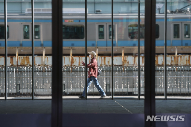 [도쿄=AP/뉴시스] 26일 한 도쿄 시민이 마스크를 쓰고 걸어가고 있다