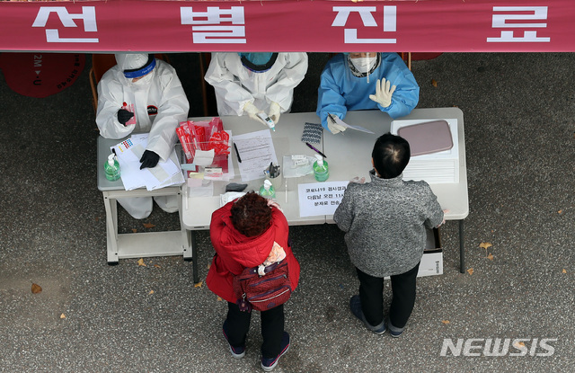[서울=뉴시스] 이영환 기자 = 이틀 연속 신종 코로나 바이러스 감염증(코로나19) 확진자가 500여명대를 보인 27일 오후 서울 강서구보건소에서 시민들이 코로나19 검사를 받기 전 의료진과 대화를 하고 있다. 2020.11.27. 20hwan@newsis.com