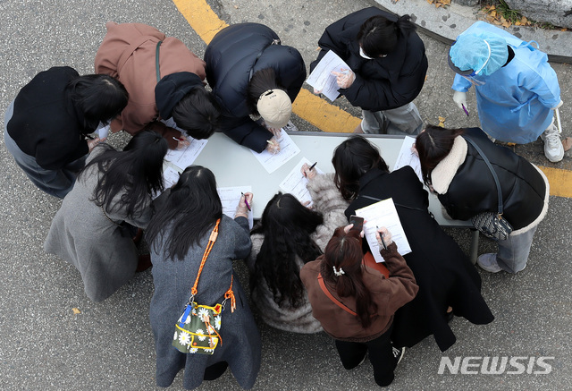 [서울=뉴시스] 이영환 기자 = 이틀 연속 신종 코로나 바이러스 감염증(코로나19) 확진자가 500여명대를 보인 27일 오후 서울 강서구보건소에서 시민들이 코로나19 검사를 받기 전 기초역학조사서를 작성하고 있다. 2020.11.27. 20hwan@newsis.com