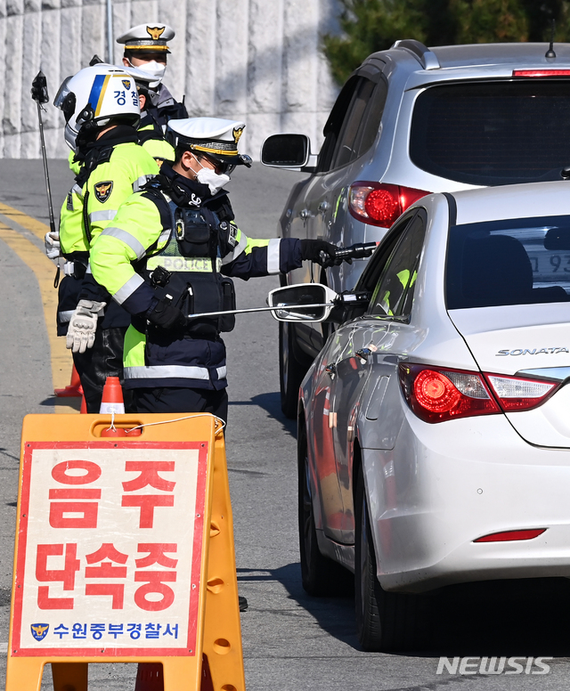 [수원=뉴시스] 김종택기자 = 30일 오후 경기도 수원시 장안구 광교산 입구에서 경기 수원중부경찰서 소속 경찰들이 대낮에 비접촉 음주감지기로 음주단속을 하고 있다. 경기남부청은 신종코로나 바이러스 감염증(코로나19) 확산에 강화된 사회적 거리두기에도 연일 음주 교통사고가 발생하자 내일부터 두달간 매주 2회 이상 연말연시 음주운전 집중단속을 실시한다. 2020.11.30.jtk@newsis.com