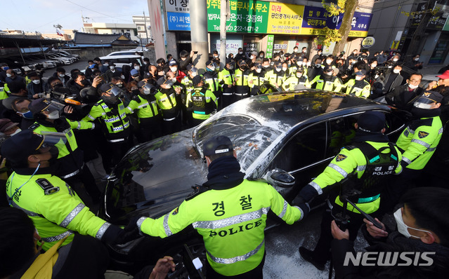 [광주=뉴시스] 류형근 기자 = 전두환 씨가 사자명예훼손 혐의로 1심 선고 공판을 받은 30일 광주지방법원 앞에서 5.18부상자회 소속 회원들이 전 전 대통령 일행 차량을 붙잡자 경찰들이 차 주위를 애워싸고 있다. (공동취재사진) 2020.11.30. photo@newsis.com