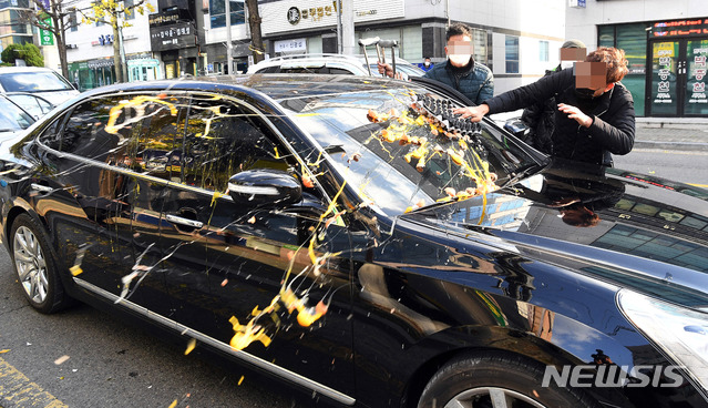 [광주=뉴시스] 류형근 기자 = 전두환 씨가 사자명예훼손 혐의로 1심 선고 공판을 받은 30일 광주지방법원 앞에서 5.18부상자회 소속 회원들이 전 전 대통령 일행 차량에 계란을 던지고 있다. (공동취재사진) 2020.11.30. photo@newsis.com