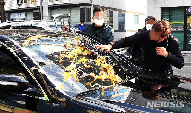 [광주=뉴시스] 류형근 기자 = 전두환 씨가 사자명예훼손 혐의로 1심 선고 공판을 받은 30일 광주지방법원 앞에서 5.18부상자회 소속 회원들이 전 전 대통령 일행 차량에 계란을 던지고 있다. (공동취재사진) 2020.11.30. photo@newsis.com