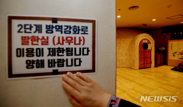 [서울=뉴시스]김병문 기자 = 사회적 거리두기 2단계를 유지하되 사우나 및 한증막 시설의 운영을 중단하는 등의 추가 조치를 취하는 '2+α' 시행을 하루 앞둔 30일 오후 서울 종로구 한 한증막 업소에서 관계자가 발한실 운영을 중단한다는 안내문을 부착하고 있다. 해당 한증막 시설 업소 사장은 "정부의 사우나 이용금지 조치를 손님들이 목욕시설까지 이용하지 못하는 것으로 오해될까 걱정이다"라고 밝혔다. 2020.11.30. dadazon@newsis.com