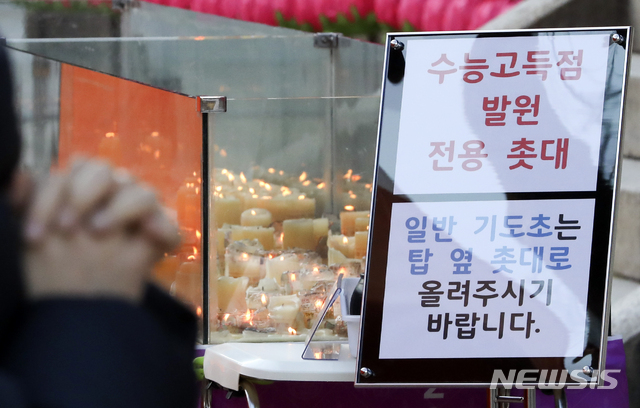 [서울=뉴시스]최진석 기자 = 2021학년도 대학수학능력시험을 사흘 앞둔 지난달 30일 서울 종로구 조계사에 마련된 수능고득점 발원 전용 촛대 앞에서 한 수험생 가족이 기도를 하고 있다. 2020.11.30. myjs@newsis.com