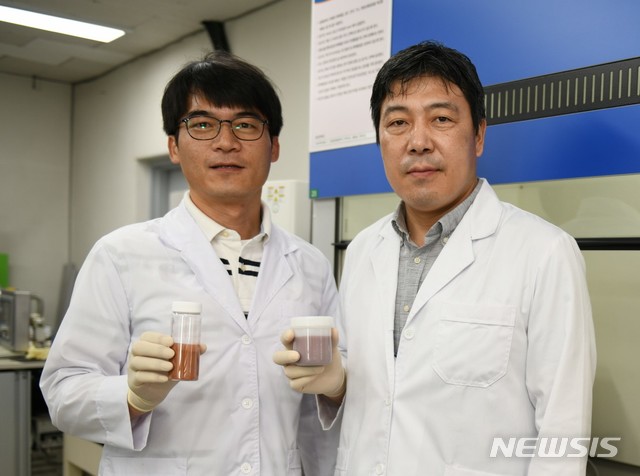 [창원=뉴시스] 홍정명 기자= 한국전기연구원 나노융합연구센터 정희진(왼쪽)·이건웅 박사가 독자 개발한 금속(구리)·그래핀 복합 파우더와 복합잉크를 들고 포즈를 취하고 있다.(사진=한국전기연구원 제공) 2020.12.01. photo@newsis.com