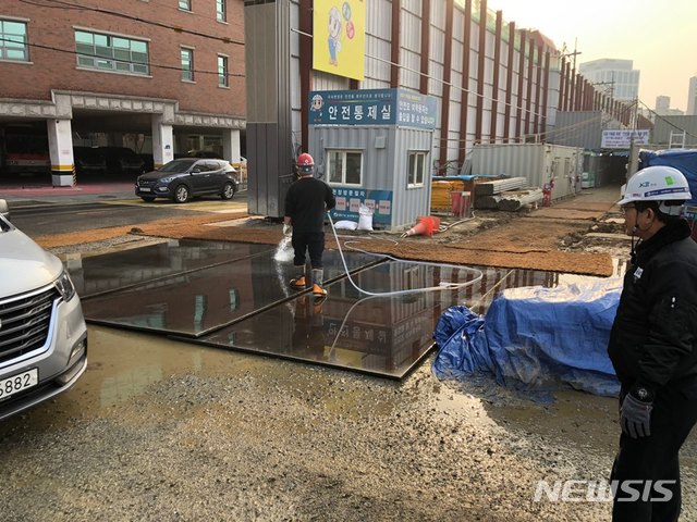 [서울=뉴시스] 서울 동작구의 공사장에서 비산먼지를 방지하기 위해 공사장 입구에 물을 뿌리는 모습. (사진=동작구 제공) 2020.12.01. photo@newsis.com 