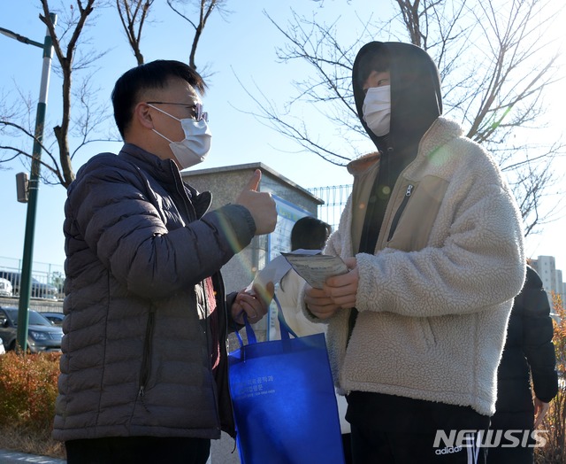 [울산=뉴시스] 구미현 기자 = 수능 예비소집일인 2일 오전 울산 약사고등학교에서 한 수험생이 담임교사로부터 격려를 받고 있다. 이날 약사고는 수험표를 워킹스루 형식으로 배부했다. (사진=울산시교육청 제공) 2020.12.2&nbsp; photo@newsis.com