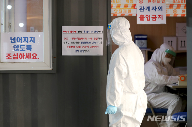 [서울=뉴시스] 조수정 기자 = 수능을 하루 앞둔 2일 성동구 보건소에 마련된 선별진료소에서 관계자가 운영시간 연장 안내문을 부착하고 있다. 서울 성동구(구청장 정원오)는 수능 전날인 2일 성동구 보건소에 마련된 선별진료소에서 22시까지 진단검사를 실시한다. (사진=성동구 제공) 2020.12.02.&nbsp; photo@newsis.com