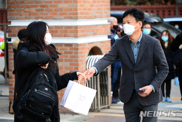 [청주=뉴시스] 인진연 기자 = 2021학년도 대학수학능력시험일인 3일 오전, 56지구 10시험장인 충북 청주 서원고등학교로 들어서는 수험생에게 아버지가 도시락을 건네고 있다. 2020.12.03&nbsp; inphoto@newsis.com 