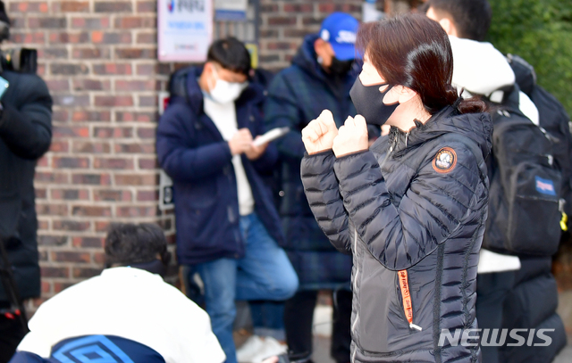 [광주=뉴시스] 류형근 기자 = 2021학년도 대학수학능력시험이 실시된 3일 오전 광주 서구 26지구 제11시험장(광덕고등학교)에서 학부모가 수험생을 격려하고 있다. 2020.12.03. hgryu77@newsis.com