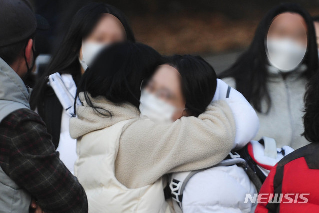 [광주=뉴시스] 류형근 기자 = 2021학년도 대학수학능력시험일인 3일 오후 광주 남구 봉선동 동아여자고등학교에서 학부모가 수능을 마친 딸을 격려해주고 있다. (사진공동취재) 2020.12.03. photo@newsis.com