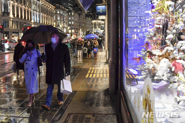 [런던=AP/뉴시스]지난 3일 영국 런던 리젠트 상점가에서 신종 코로나바이러스 감염증(코로나19) 확산 방지를 위해 마스크를 쓴 사람들이 쇼핑백을 들고 걷고 있다. 2020.12.09.