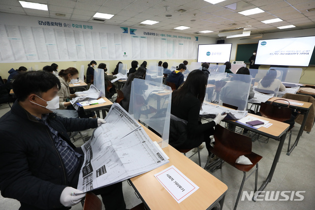 [서울=뉴시스] 조수정 기자 = 4일 오후 서울 강남구 종로학원에서 열린 2021학년도 대학수학능력시험 합격 예측 점수 설명회에서 학부모들이 칸막이를 사이에 두고 거리두기를 하며 앉아 배치참고표를 보고 있다. 2020.12.04. chocrystal@newsis.com