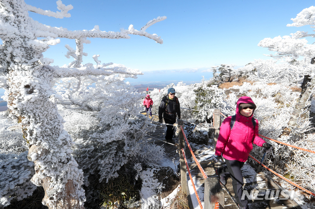 [제주=뉴시스]우장호 기자 = 눈 쌓인 제주 한라산 영실 코스 탐방로를 찾은 등반객들이 밝은 표정으로 눈꽃을 감상하고 있다. (뉴시스DB) woo1223@newsis.com