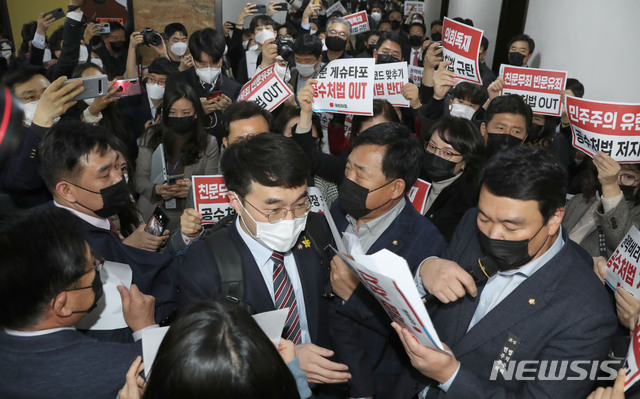 [서울=뉴시스] 최동준 기자 = 7일 오후 국민의힘 의원들이 더불어민주당의 고위공직자범죄수사처(공수처)법 개정안 등 입법 강행에 맞서 서울 국회 법사위 회의실 앞에 집결해 규탄 구호를 외치는 가운데 더불어민주당 김남국 의원이 국민의힘 의원들 사이를 뚫고 회의장으로 들어가고 있다. (공동취재사진) 2020.12.07. photo@newsis.com