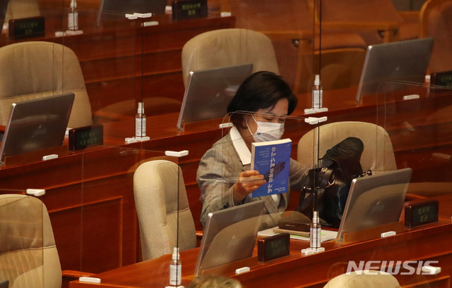 [서울=뉴시스] 김진아 기자 = 추미애 법무부 장관이 9일 오후 서울 여의도 국회에서 열린 본회의에 참석하며 '내가 검찰을 떠난 이유'라는 책을 가방에서 꺼내고 있다. (공동취재사진) 2020.12.09. photo@newsis.com