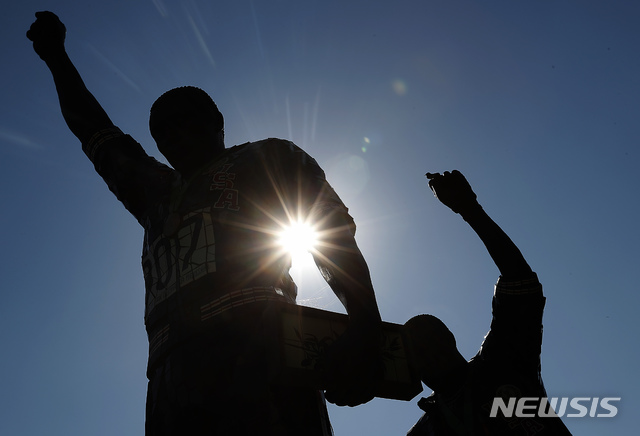 [새너제이(미 캘리포니아주)=AP/뉴시스]미 캘리포니아주 새너제이의 새너제이주립대학 캠퍼스에 지난 2018년 10월17일 1968년 멕시코올림픽 시상대에서 주먹을 치켜들고 미국의 흑백 차별에 항의하는 시위를 벌여 축출된 토미 스미스(왼쪽)와 존 카를로스의 동상이 보이고 있다. 미국 올림픽·장애인올림픽위원회(USOPC)는 10일(현지시간) 2021년 도쿄올림픽대회와 그 이후 대회 메달 시상대에서 주먹을 치켜들거나 무릎을 꿇는 것에 대해 제재하지 않을 것이라고 발표, 미국 선수들의 요구를 수용했다. 2020.12.11