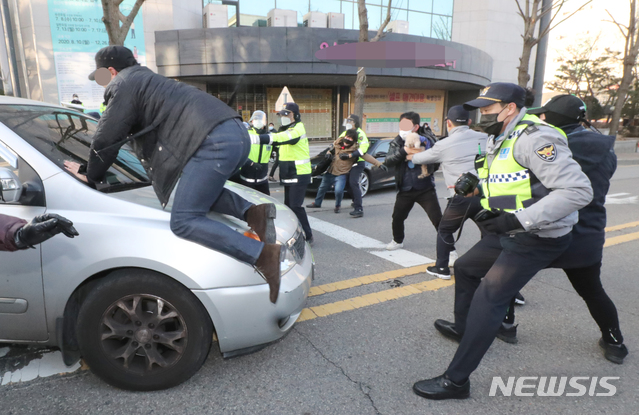 [안산=뉴시스] 김종택기자 = 아동 성범죄자 조두순(68) 출소일인 12일 오전 일부 시민들이 경기도 안산준법지원센터를 나서 집으로 향하는 호송차량을 막고 있다. 2020.12.12.jtk@newsis.com