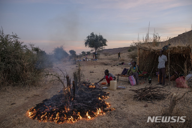 [카다리프=AP/뉴시스]지난해 12월14일(현지시간) 수단 동부 카다리프의 움 라쿠바 난민 캠프에서 한 티그라이 난민 남성이 가족을 위한 저녁을 만들기 위해 불을 지피고 있다. 에티오피아 중앙정부와 북부 티그라이인민해방전선(TPLF)간 내전으로 지금까지 5만여 명의 난민이 수단으로 피신했다. 2021.02.08