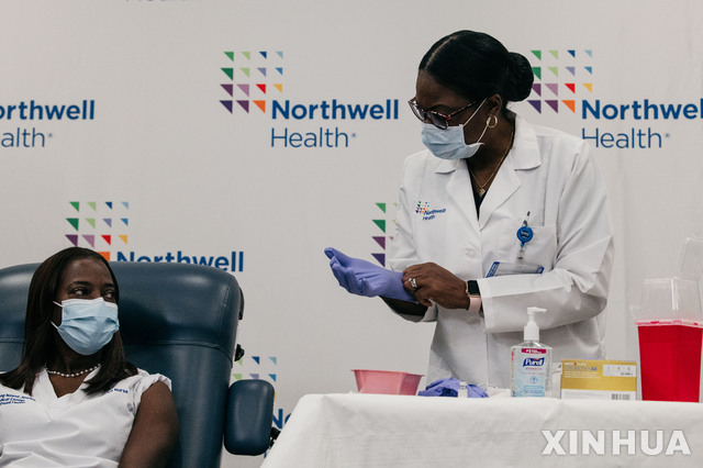 [ 신화/뉴시스] 뉴욕 롱아일랜드의 코로나 집중센터 간호사 샌드라 린제이가 14일 롱아일랜드 유대 의료센터에서 코란19 백신주사를 맞고 있다.&nbsp; 