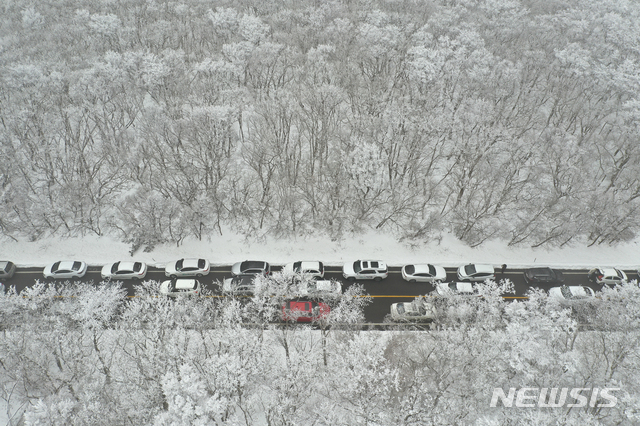 [서귀포=뉴시스]우장호 기자 = 제주 한라산에 1m가 넘는 폭설이 내린 가운데 17일 오후 제주 한라산 1100고지 휴게소 인근 도로에 관광객들이 찾아와 설경을 감상하며 즐거운 시간을 보내고 있다. 2020.12.17. woo1223@newsis.com