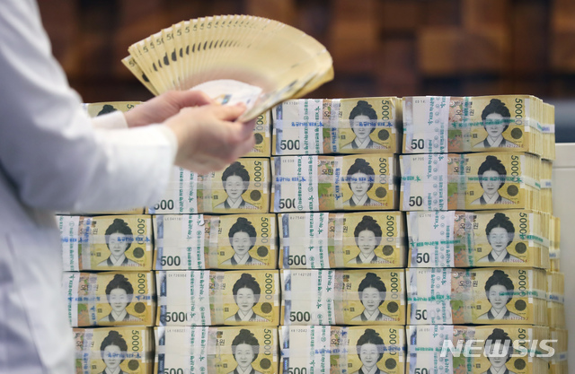 [서울=뉴시스] 고승민 기자 = 17일 서울 중구 하나은행에서 관계자가 원화를 들어 보이고 있다. 2020.12.17. kkssmm99@newsis.com