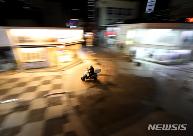 [제주=뉴시스]우장호 기자 = 제주형 사회적 거리두기 2단계 시행 첫날인 18일 오후 인적이 드문 제주시 연동 누웨마루 거리에 배달 오토바이만 분주히 움직이고 있다. 2020.12.18. woo1223@newsis.com