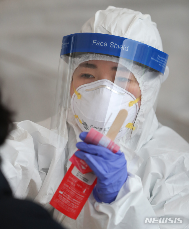 [제주=뉴시스]우장호 기자 = 제주 도내 신종 코로나바이러스 감염증(코로나19) 확진자가 속출한 18일 오후 제주시보건소에 마련된 선별진료소에서 의료진들이 구슬땀을 흘리며 검체 채취에 집중하고 있다. 2020.12.18. woo1223@newsis.com