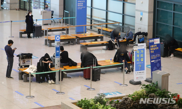 [인천공항=뉴시스]배훈식 기자 = 수도권 5인 이상 집합금지를 하루 앞둔 지난 22일 오후 인천국제공항 제1터미널 입국장에서 해외 입국자들이 대기하고 있다. 2020.12.22. dahora83@newsis.com