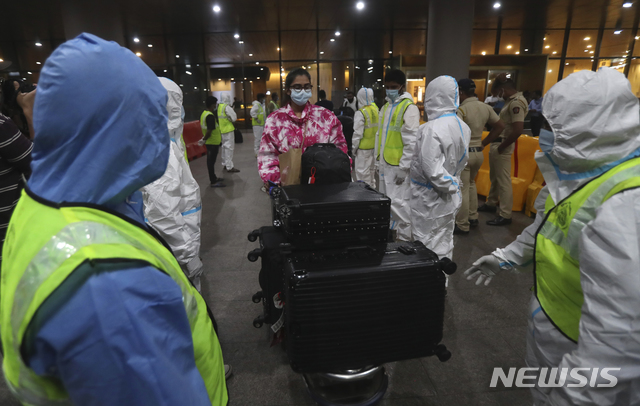 [뭄바이=AP/뉴시스]지난 2020년 12월22일 인도 뭄바이의 차트라파티 시바지 마하라즈 국제공항에서 개인보호장비(PPE)를 착용한 현지 보건 관계자들이 영국에서 도착하는 승객들을 안내하고 있다. 2021.08.04.